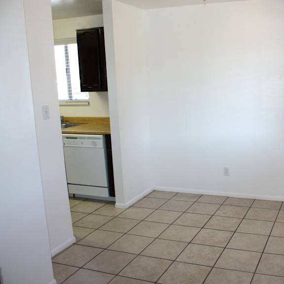 a white room with a tiled floor and a door on the right.