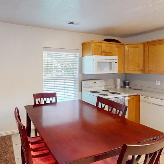 a kitchen with a table and chairs in front of a fireplace.
