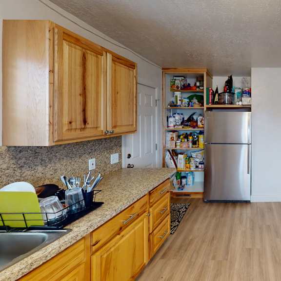 a kitchen with wooden cabinets and a granite countertop.