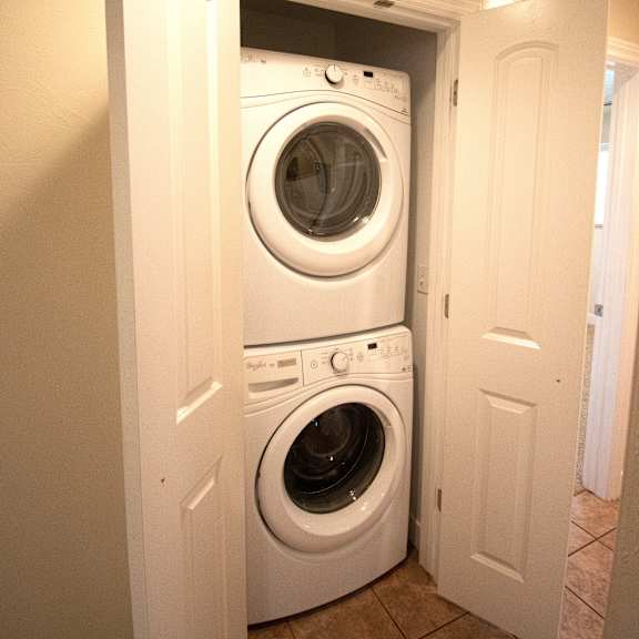 a white door is open to reveal a white washing machine.