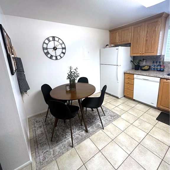 a kitchen with a table and chairs and a clock on the wall.