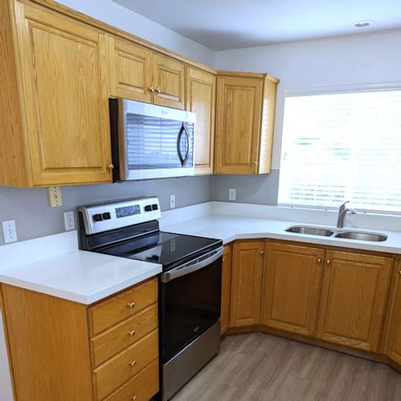 a kitchen with wooden cabinets and a black stove top oven.