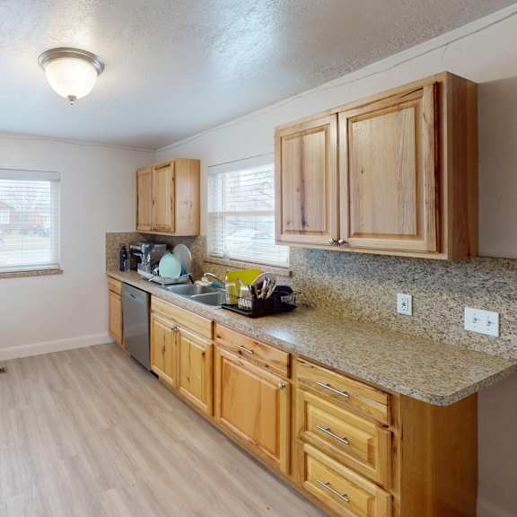 a kitchen with wooden cabinets and a granite countertop.