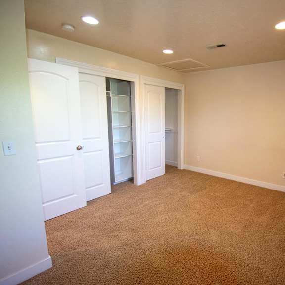 a room with a carpeted floor and a window on the right side.