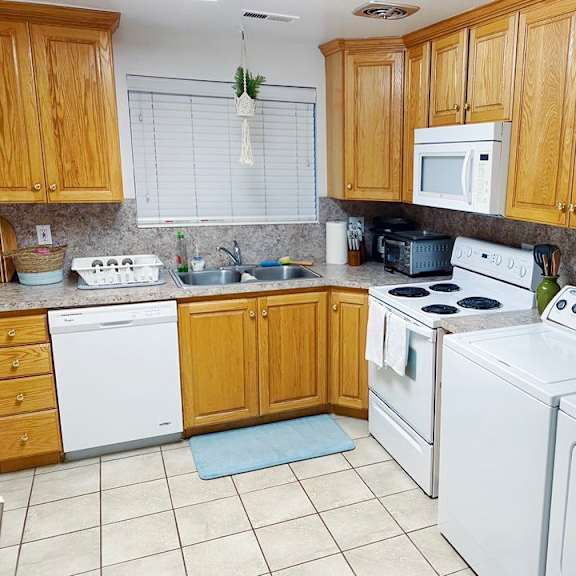 a kitchen with white appliances and wooden cabinets.
