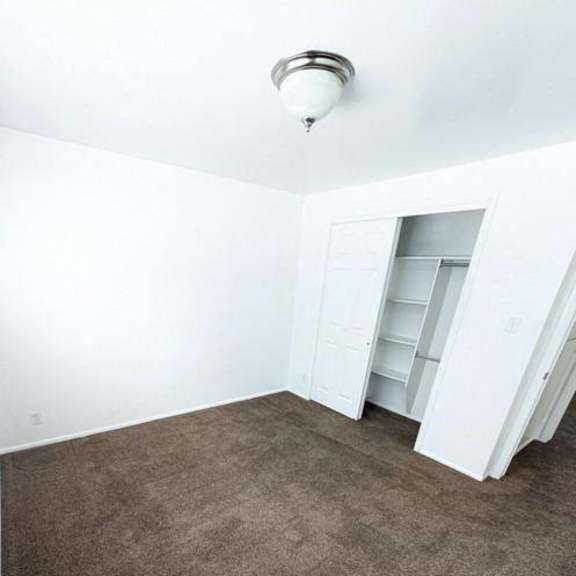 a room with a carpeted floor and a white ceiling with a light fixture.