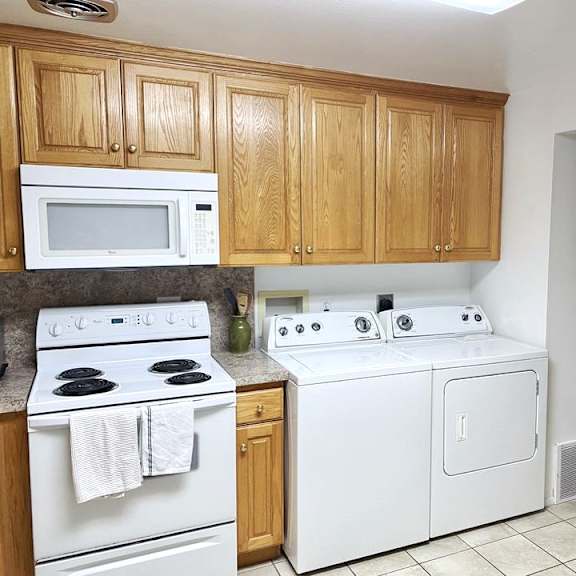 a kitchen with white appliances and wooden cabinets.