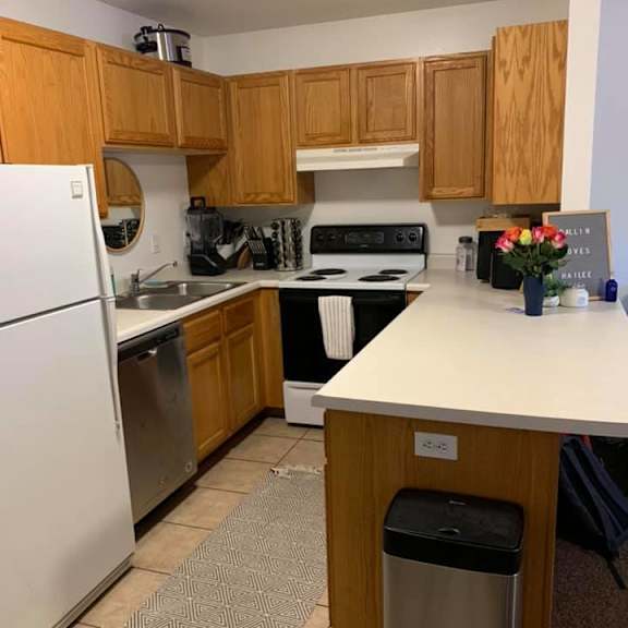 a kitchen with wooden cabinets and a white refrigerator.