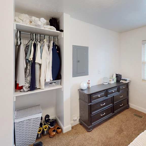 a bedroom with a bed, dresser, and closet.