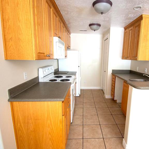 a kitchen with wooden cabinets and a black countertop.