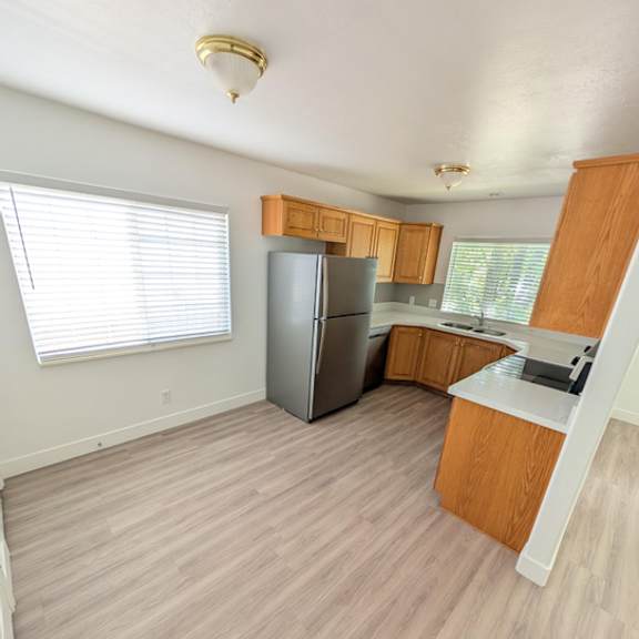 a kitchen with wooden cabinets and a refrigerator.