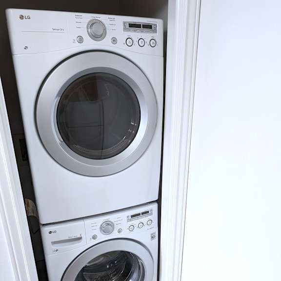 two white lg front load washing machines in a small space.