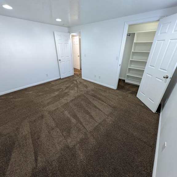 a room with brown carpet and white walls.