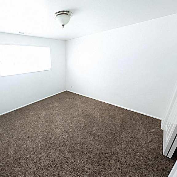 a room with a carpeted floor and a window.