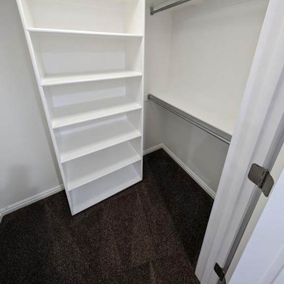 a white shelving unit in a room with a white door.