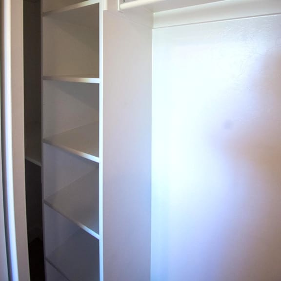 empty white shelves in a white refrigerator.
