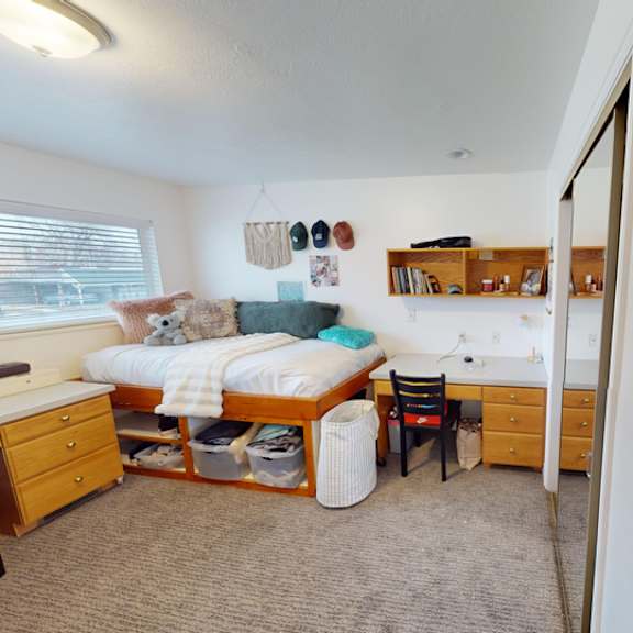 a bedroom with a bed, dresser, and chair.