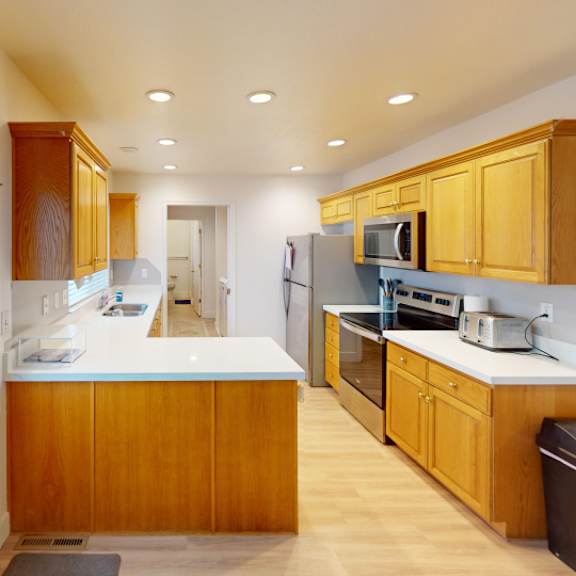 a kitchen with wooden cabinets and a white counter.