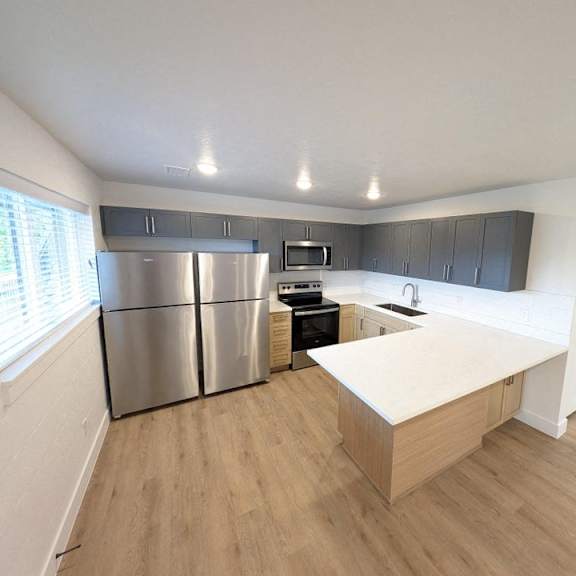 a kitchen with a large island and stainless steel refrigerator