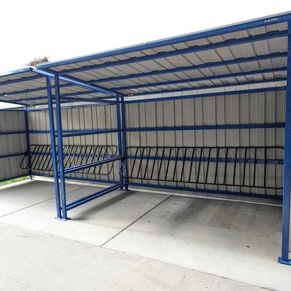 a metal container with a roof on top of a sidewalk