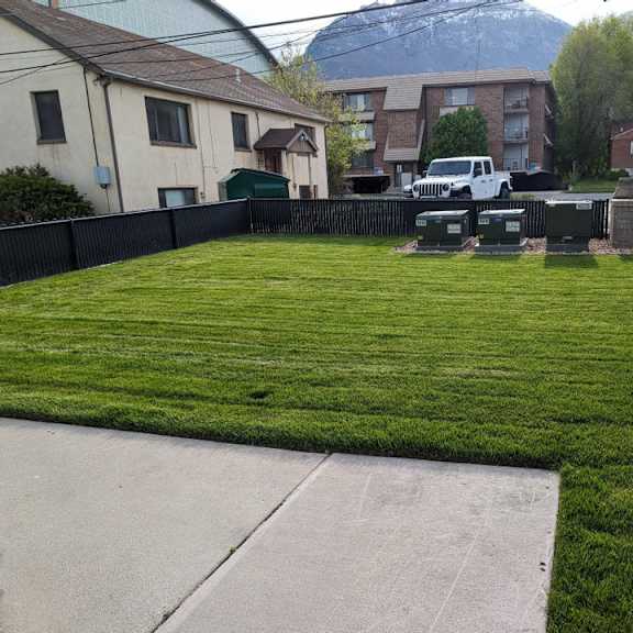 a yard with lawn chairs and a fence