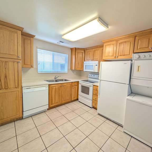 a kitchen with wooden cabinets and white appliances.