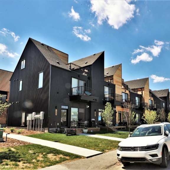 a row of houses with cars parked in front of them