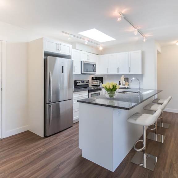 a kitchen with white cabinetry and stainless steel appliances