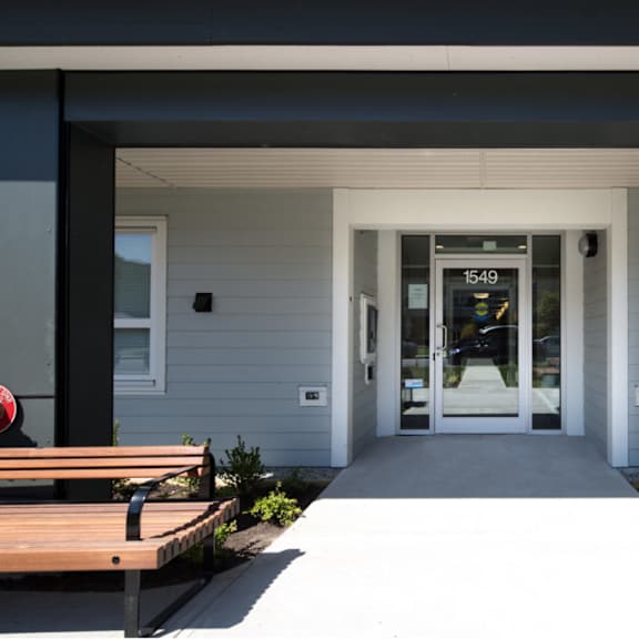 a view of the front of the building with the doors open and a bench in front of