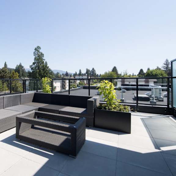 a seating area on the roof of a building with a view of the mountains in the background