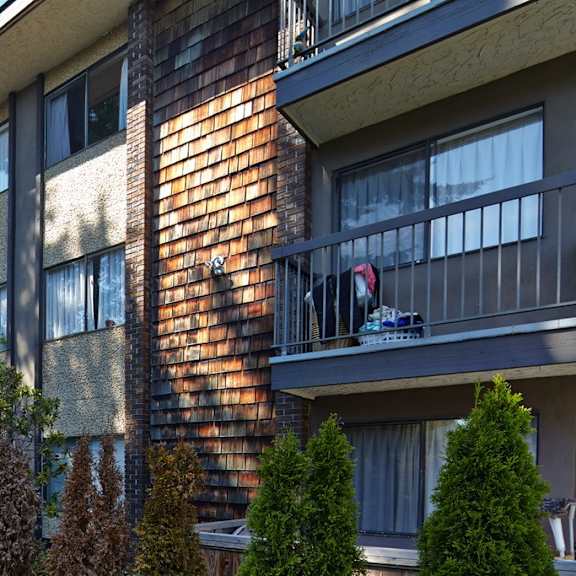 an apartment building with a dog on a balcony