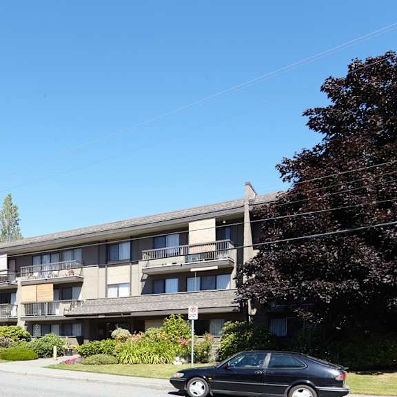 a large apartment building with cars parked in front of it