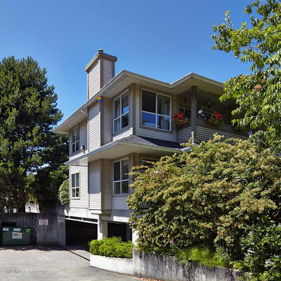 a house with a large garage and trees in front of it