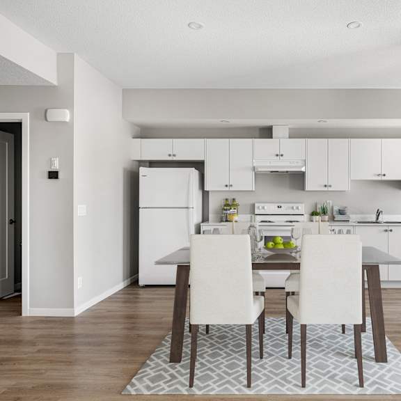 a kitchen and dining room with white cabinets and a table and chairs