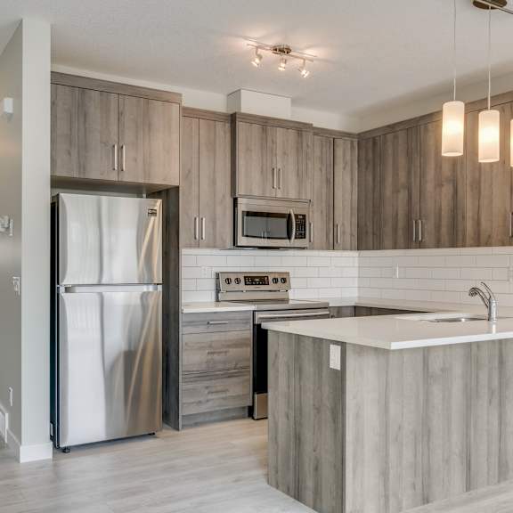 a kitchen with a white counter top and a refrigerator