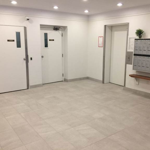 a large room with white walls and a tiled floor