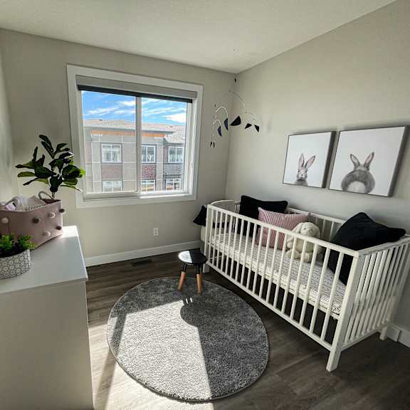 a nursery with a crib and a dresser and a window