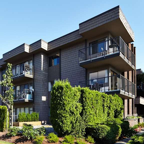 a picture of an apartment building with a blue sky in the background
