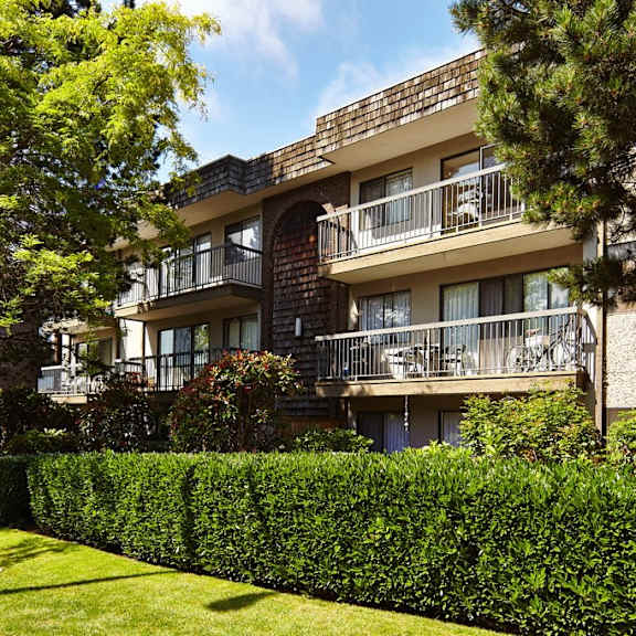 an apartment building with balconies and a manicured lawn