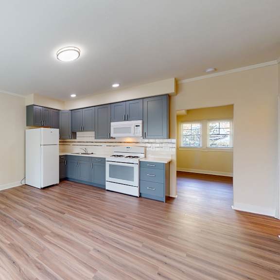 a kitchen with a white refrigerator, white stove, and white oven.