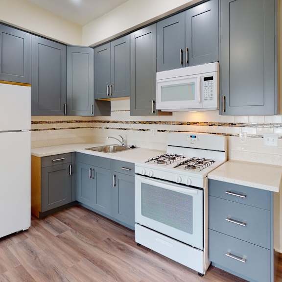a kitchen with a white refrigerator and a white stove top oven.