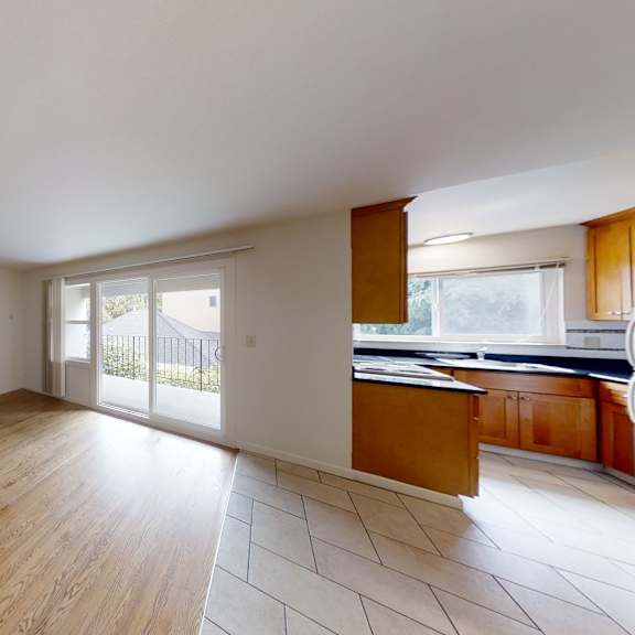 a spacious room with wooden floors and white walls.