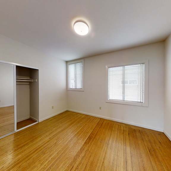 a room with wooden floors and a large mirror on the wall.