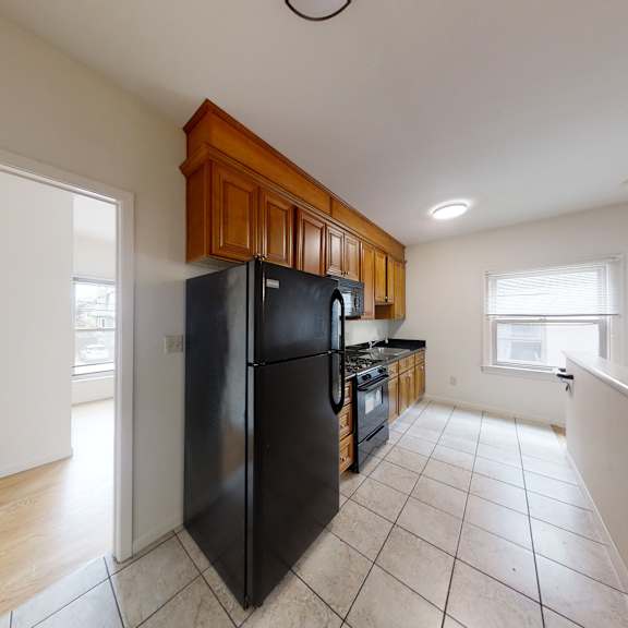 a kitchen with black appliances and wooden cabinets.