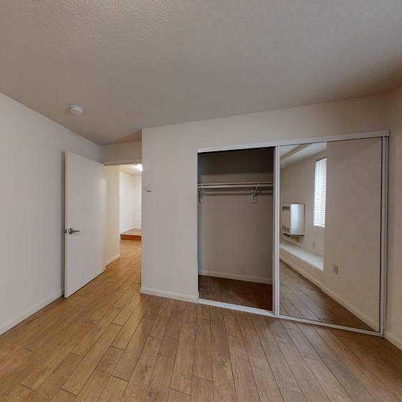 a room with a white wall and a wooden floor.