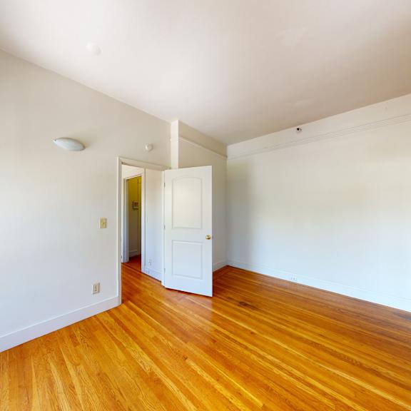 a room with wooden floors and white walls.