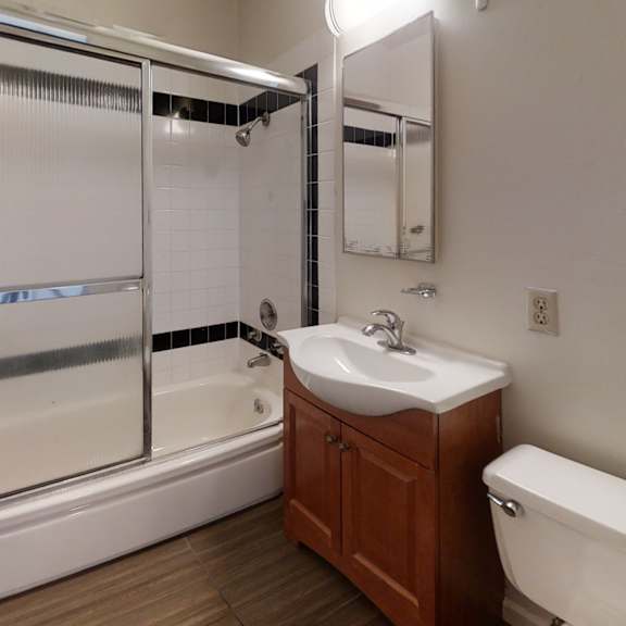 a white bathroom with a sink, mirror, and tub.