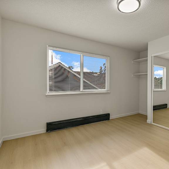 a room with a window and a mirror on the wall.