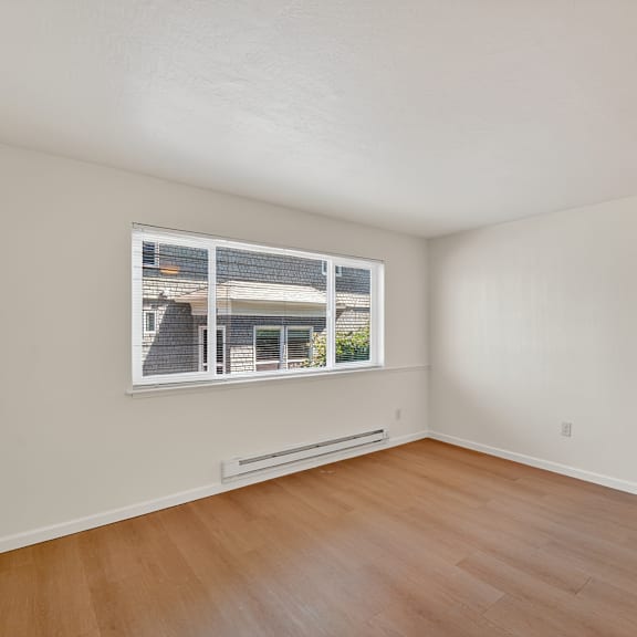 a room with a window and wooden flooring.