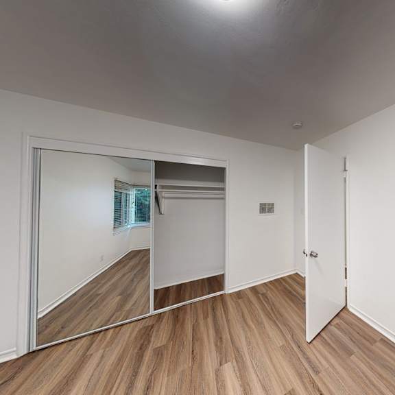 a room with a wooden floor and a mirror on the wall.